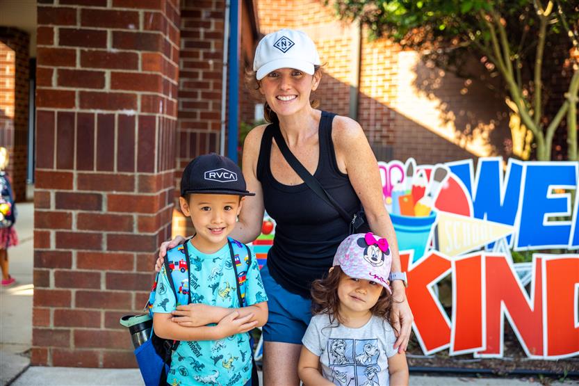 A family smiles on the first full day of kindergarten